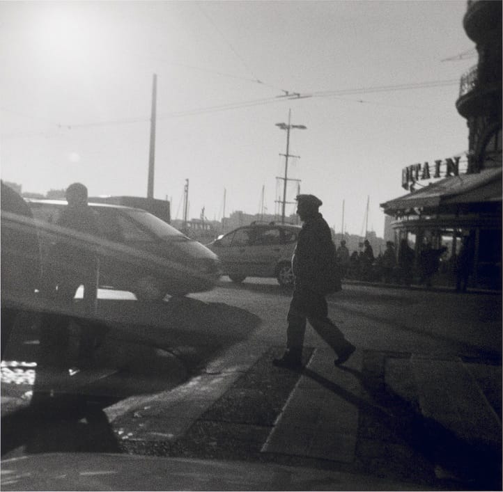Photographie carrée de Bernard Plossu prise à l'Agfamatic : un homme traverse un quai à contre-jour