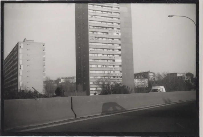 Une tour d'habitation et une voie rapide vues par-dessus une glissière de sécurité
