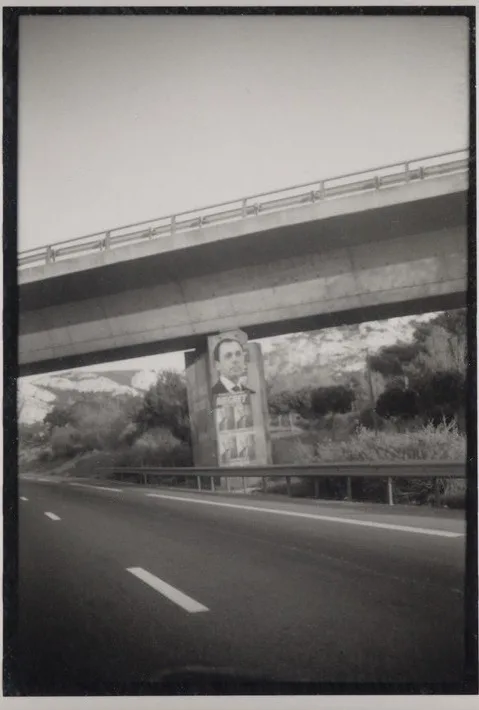 Une autoroute passant sous un viaduc, la bande blanche au premier plan