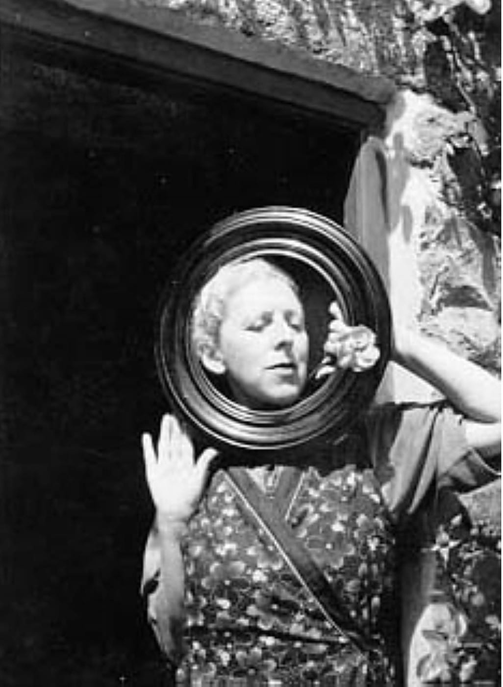 Claude Cahun tenant un cadre rond devant son visage