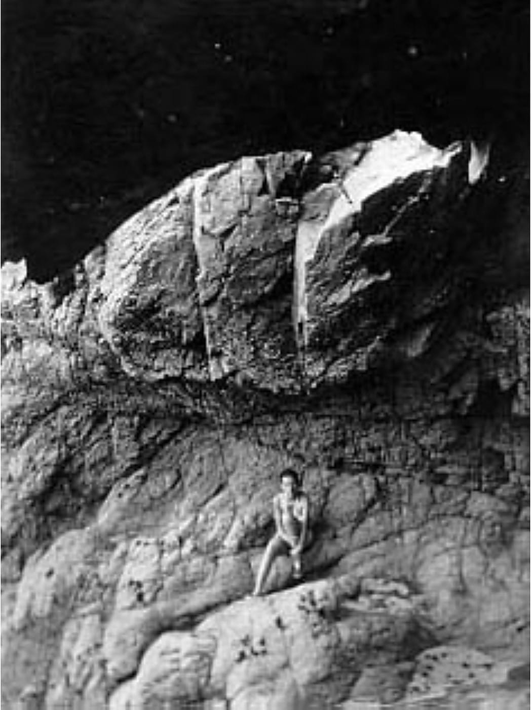 Claude Cahun debout à l'entrée d'une grotte