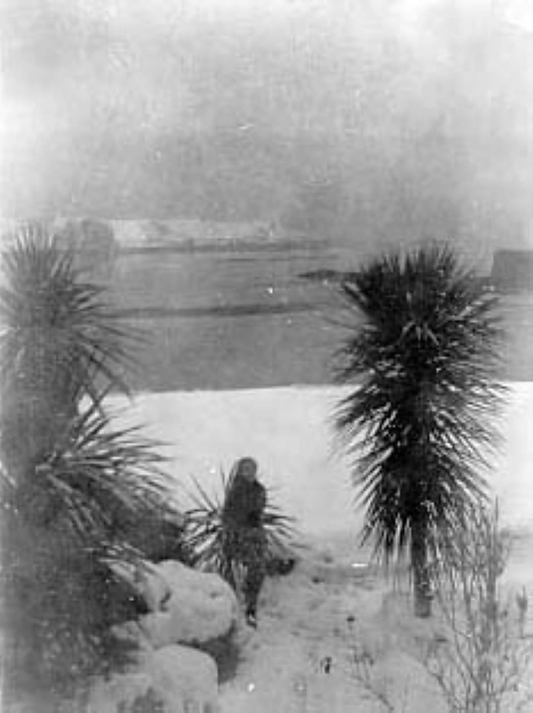 Claude Cahun accroupie dans la neige, au bord de la baie