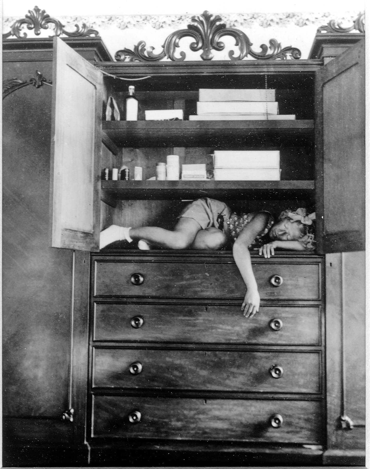 Claude Cahun repliée à l'intérieur d'un placard
