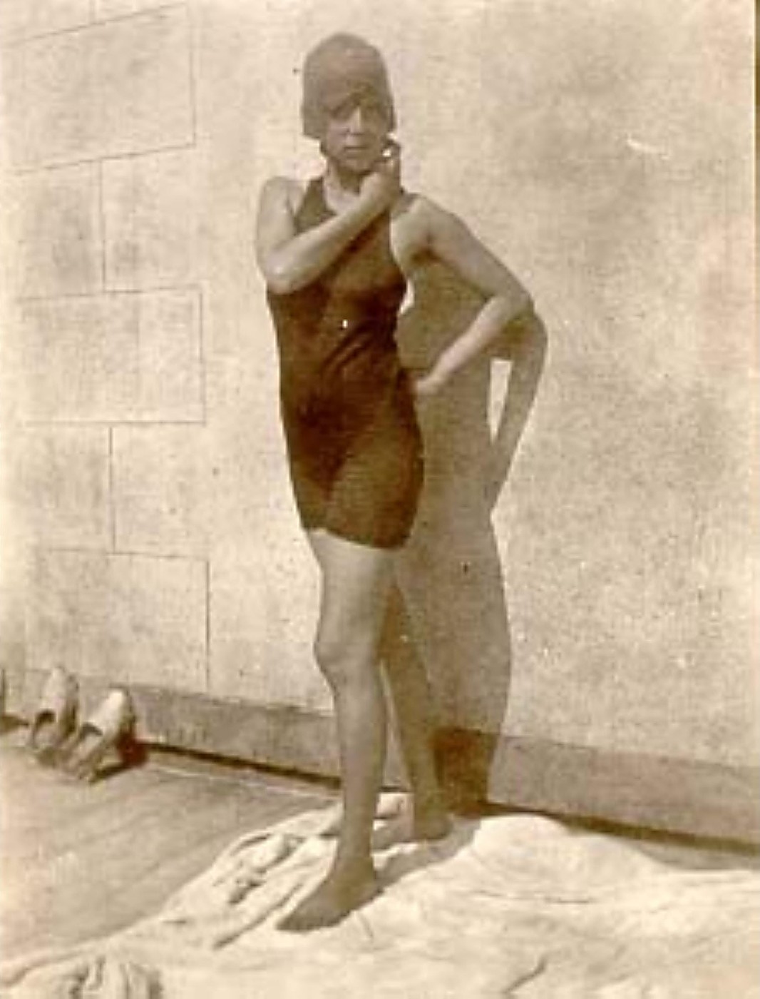 Claude Cahun jeune fille en maillot de bain, debout contre un mur