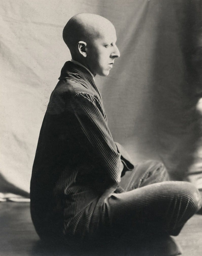 Claude Cahun, autoportrait de profil, crâne rasé, assise en tailleur