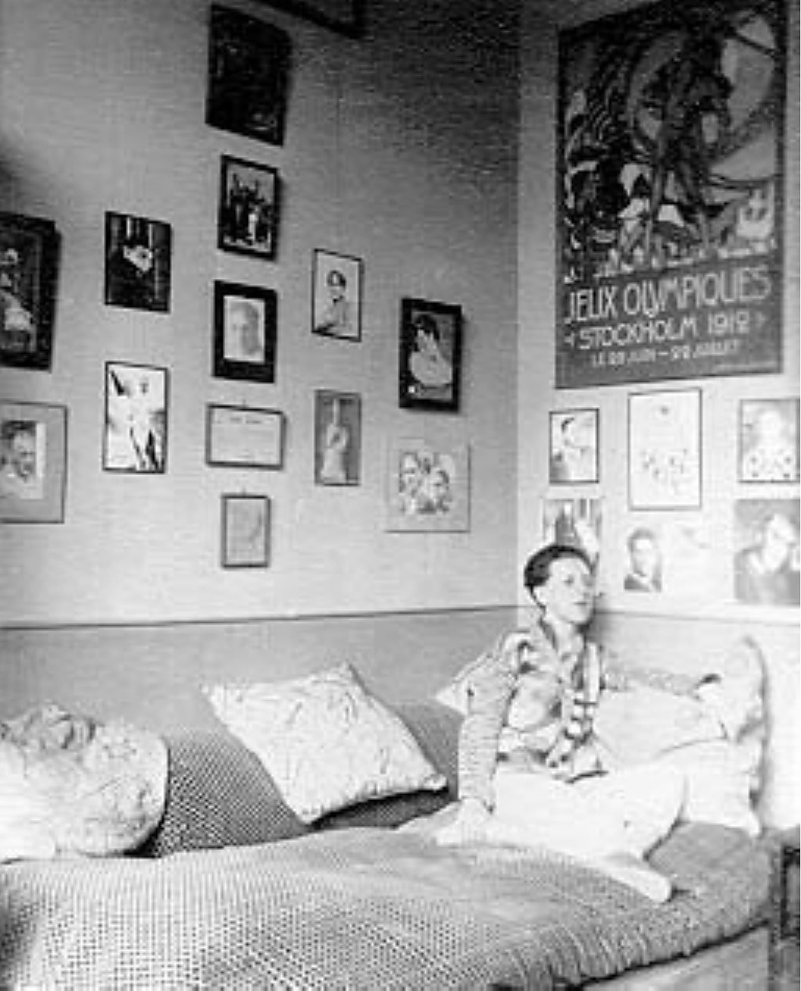 Claude Cahun, autoportrait allongée sur un lit dans un intérieur parisien