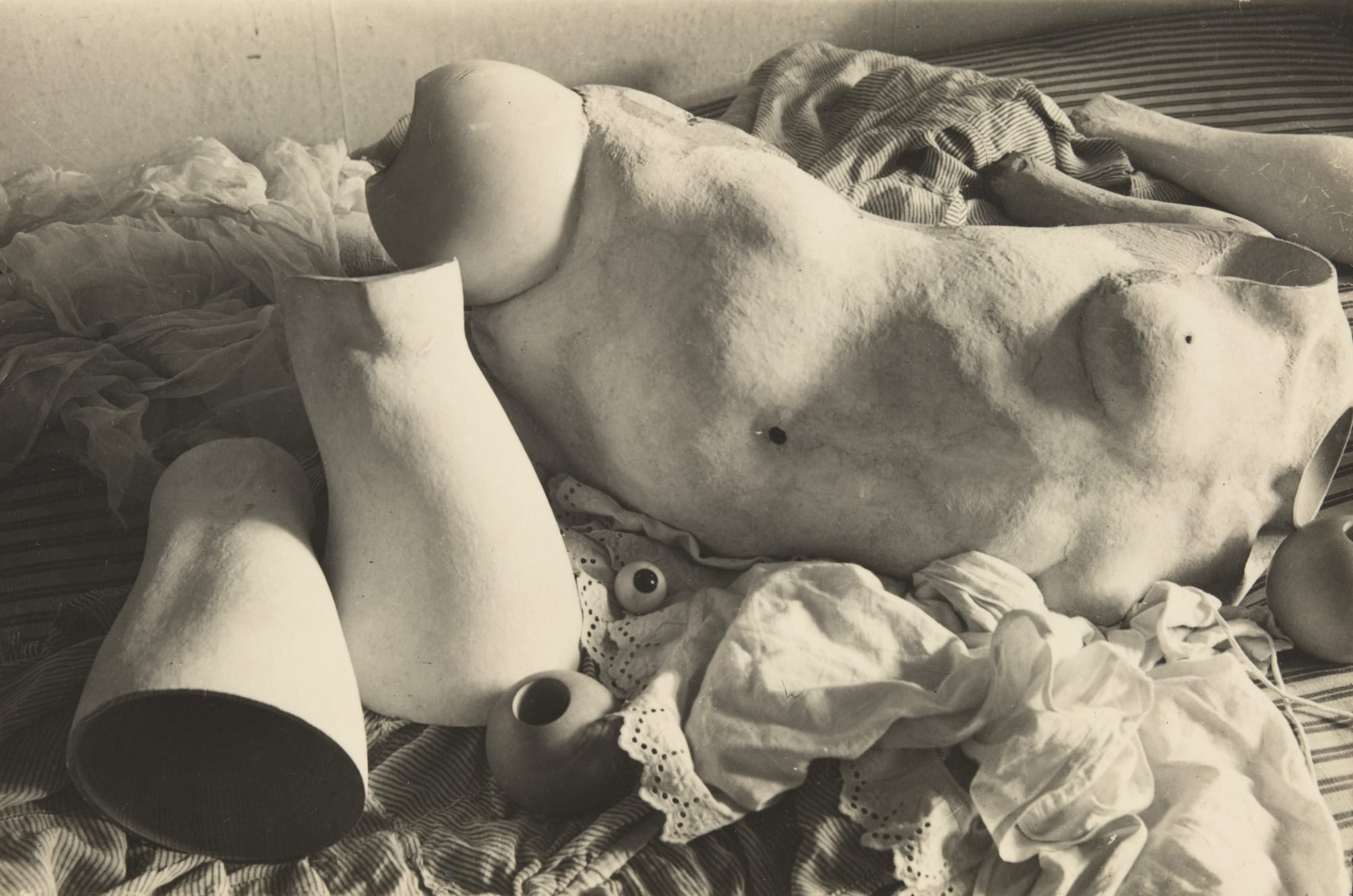 Membres de poupée démontés posés sur du linge, planche de La Poupée de Hans Bellmer, 1936