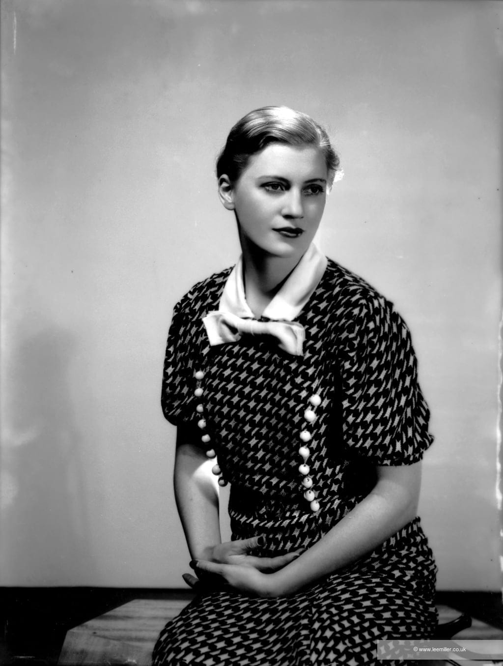 Autoportrait de Lee Miller en robe à nœud blanc dans son studio new-yorkais en 1932