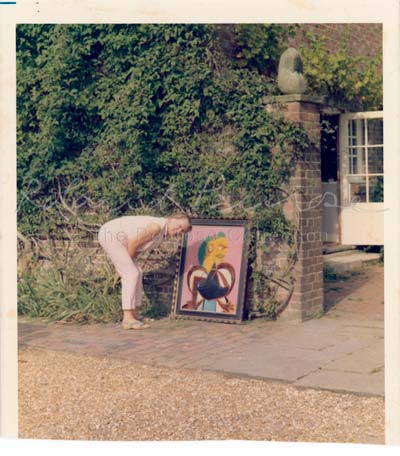 Lee Miller en 1965 posant à côté d’un portrait peint d’elle