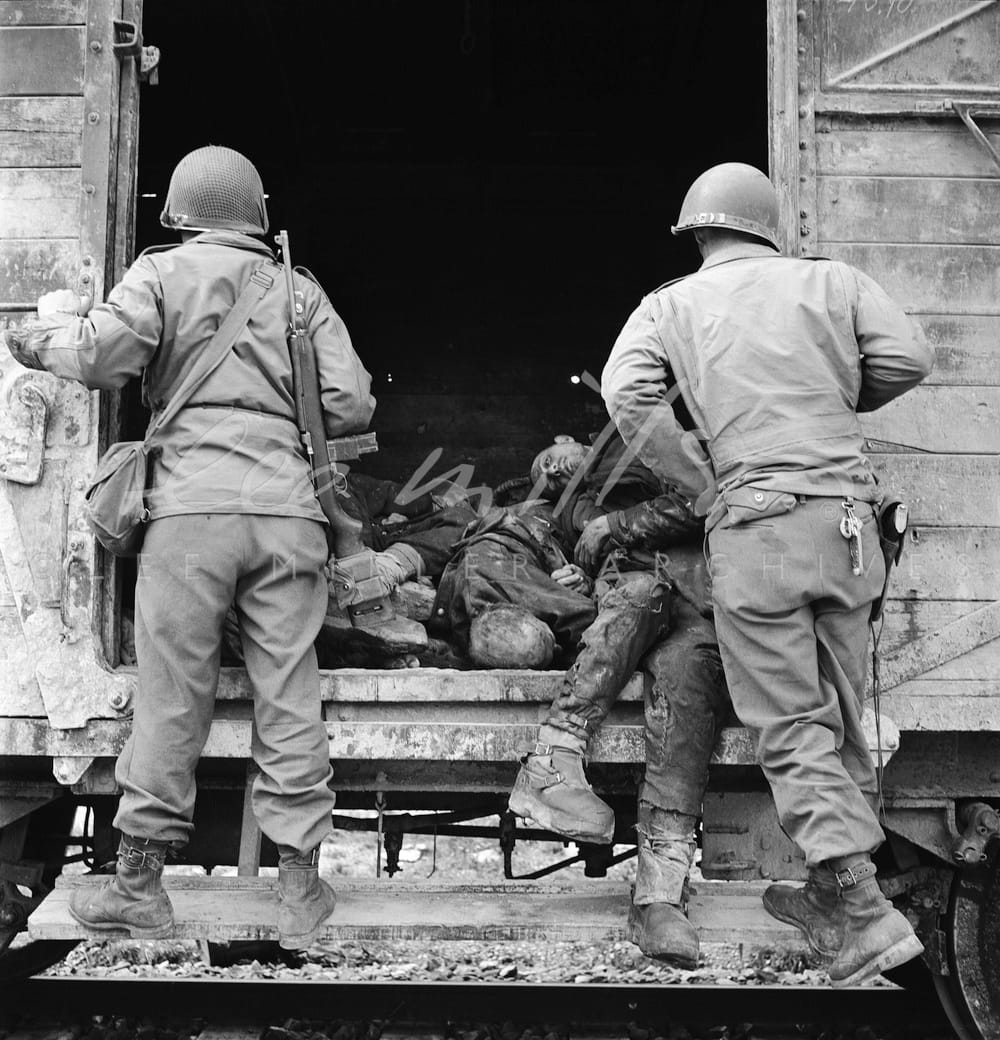 Soldats américains examinant un wagon de prisonniers morts photographié par Lee Miller en 1945