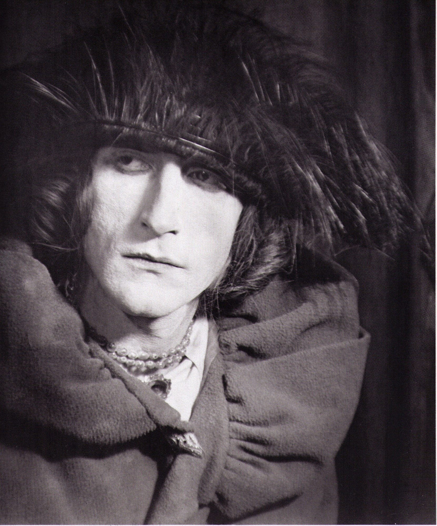 Marcel Duchamp en Rrose Sélavy, coiffé d’un chapeau à plumes et d’un col de fourrure, photographie de Man Ray, 1921