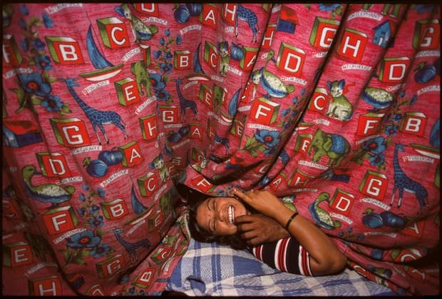 Enfant endormi sous un rideau à lettres, Falkland Road, Bombay, 1978, par Mary Ellen Mark