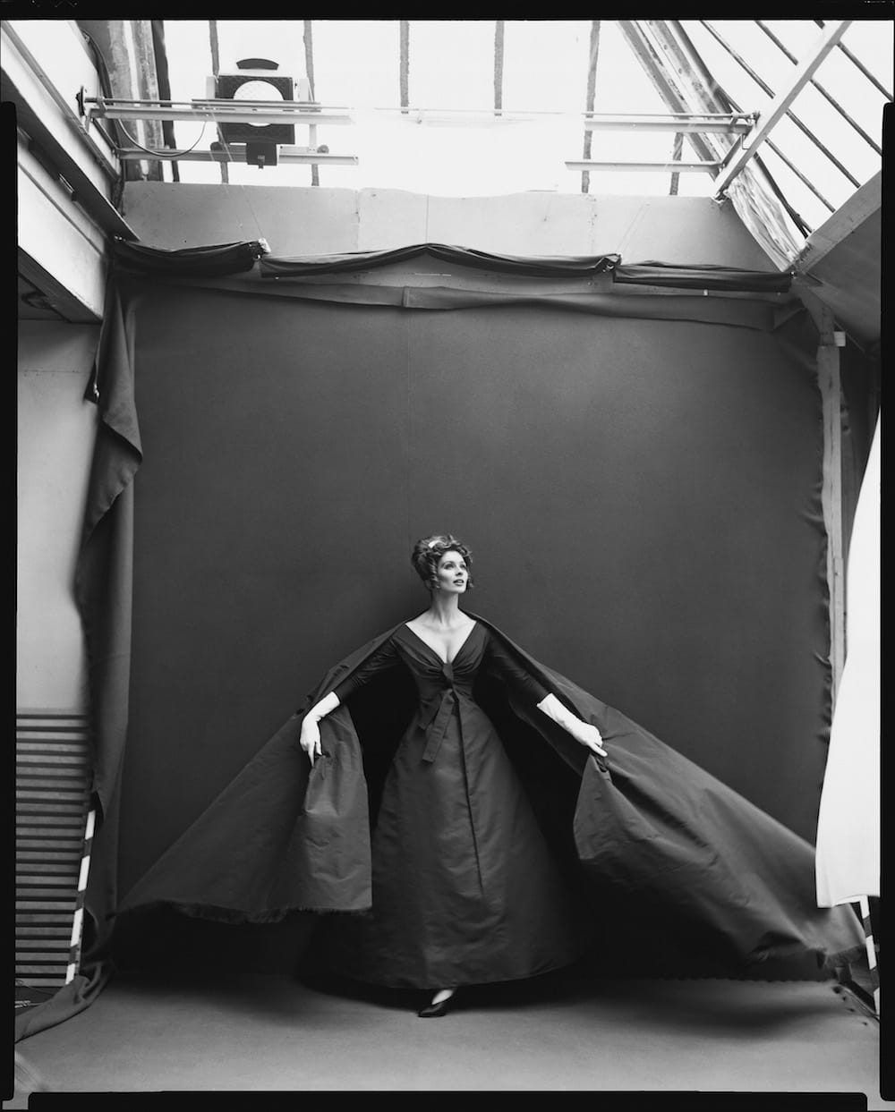 Suzy Parker en robe Dior Musique de Nuit devant le fond de studio parisien, par Richard Avedon