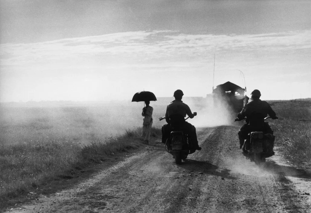 Des motocyclistes et une femme sur la route de Thái Bình