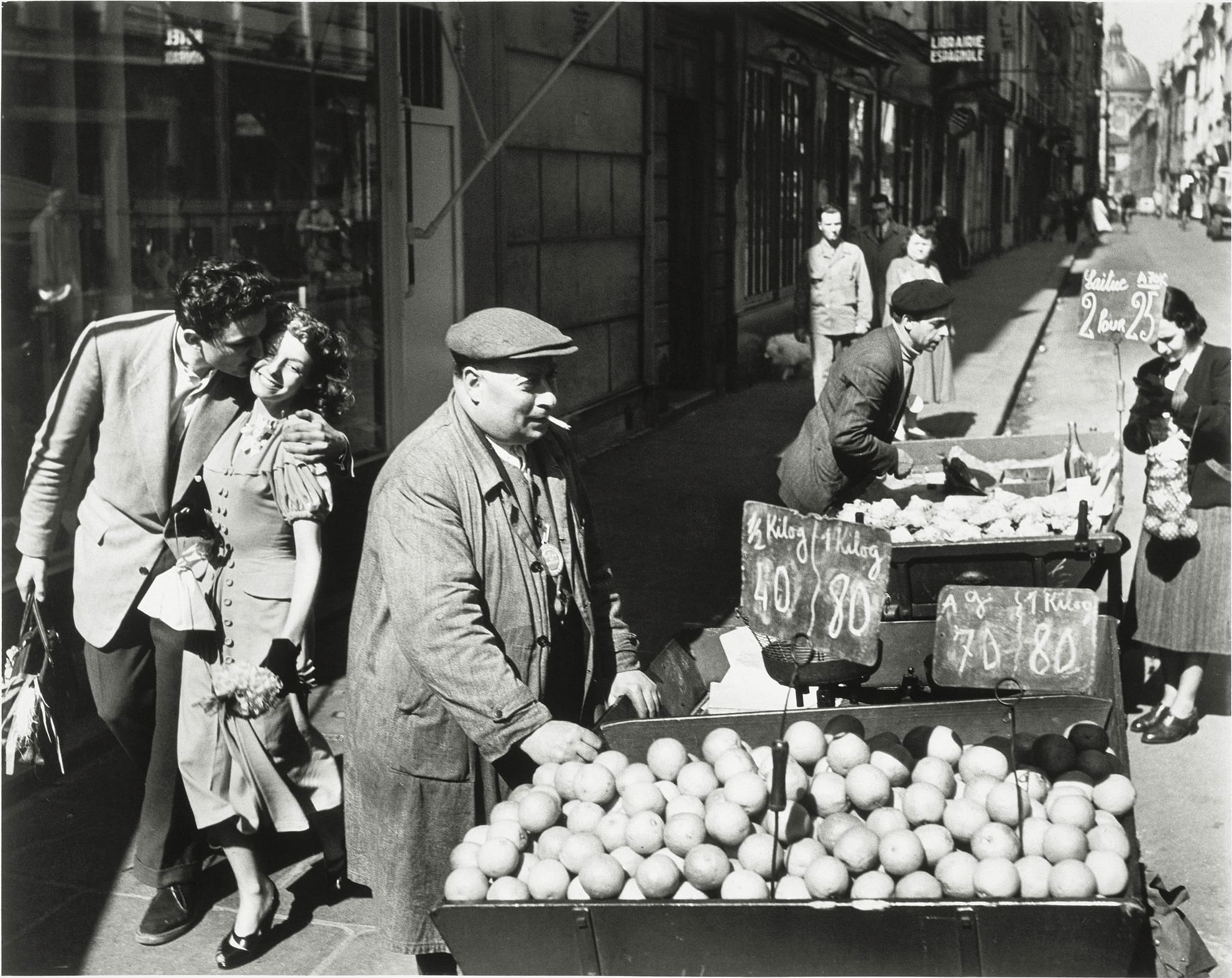 Un couple s'embrasse devant la charrette d'un marchand d'oranges rue Mazarine, Robert Doisneau, 1950