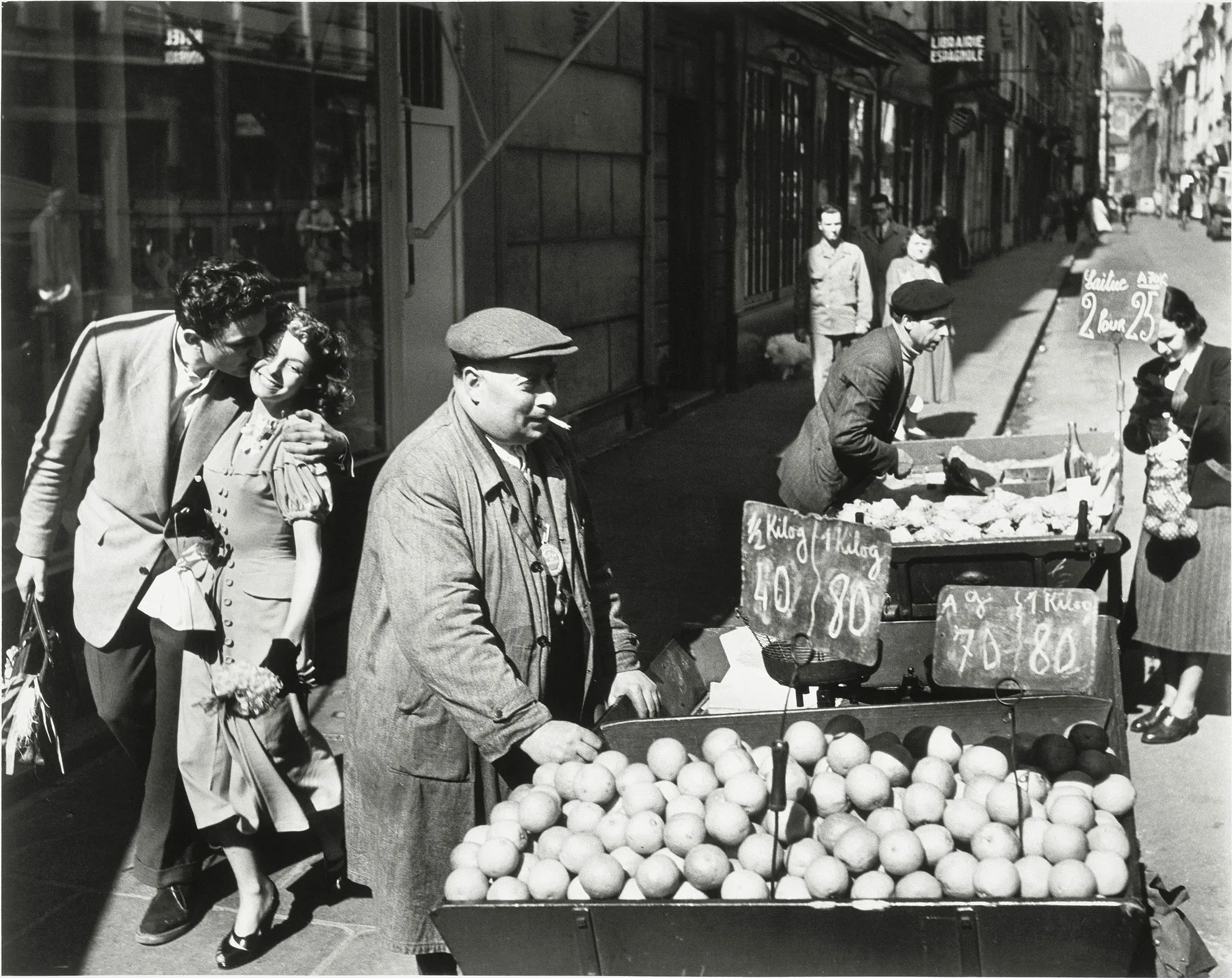 Un couple s'embrasse devant la charrette d'un marchand d'oranges rue Mazarine, Robert Doisneau, 1950
