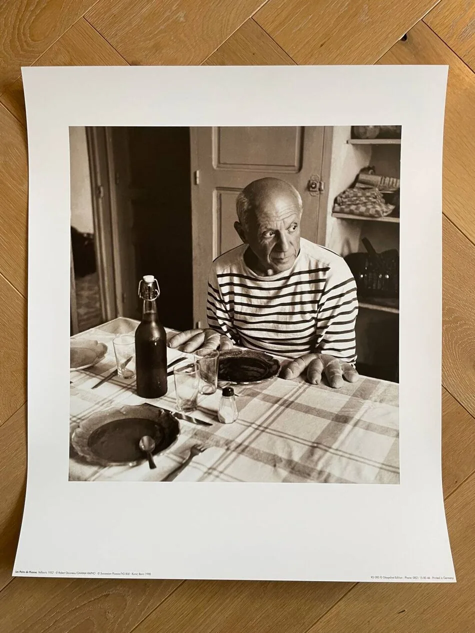Picasso attable devant les pains a quatre doigts, Vallauris, Robert Doisneau, 1952
