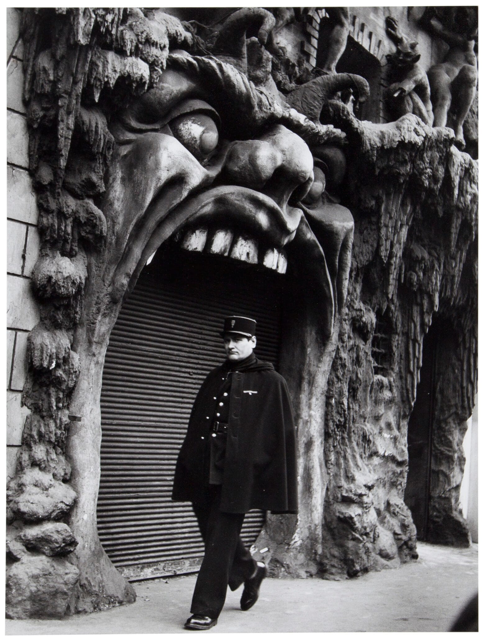 Un agent devant la facade en forme de gueule de monstre du cabaret de la Porte de l Enfer, boulevard de Clichy, Robert Doisneau