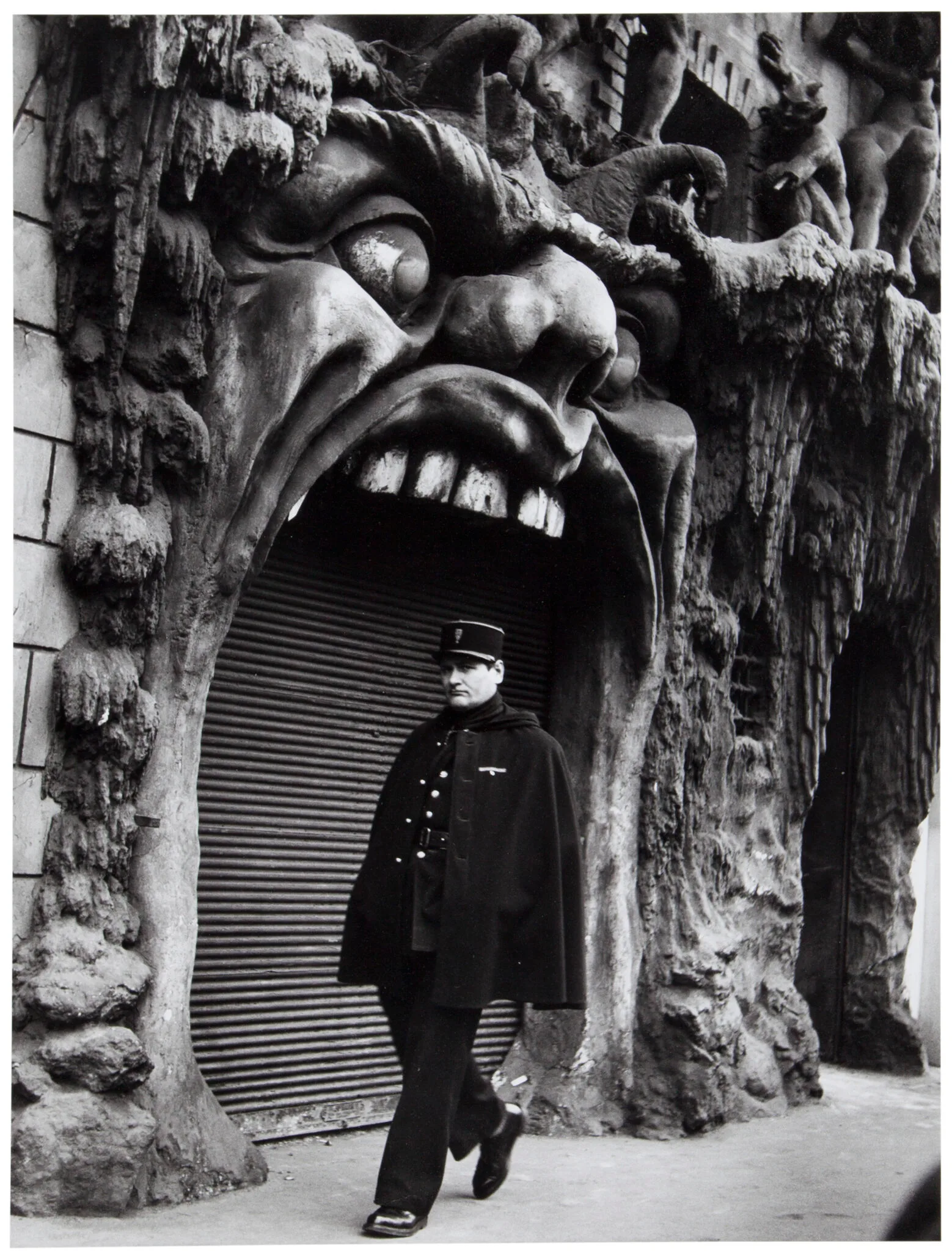 Un agent devant la facade en forme de gueule de monstre du cabaret de la Porte de l Enfer, boulevard de Clichy, Robert Doisneau