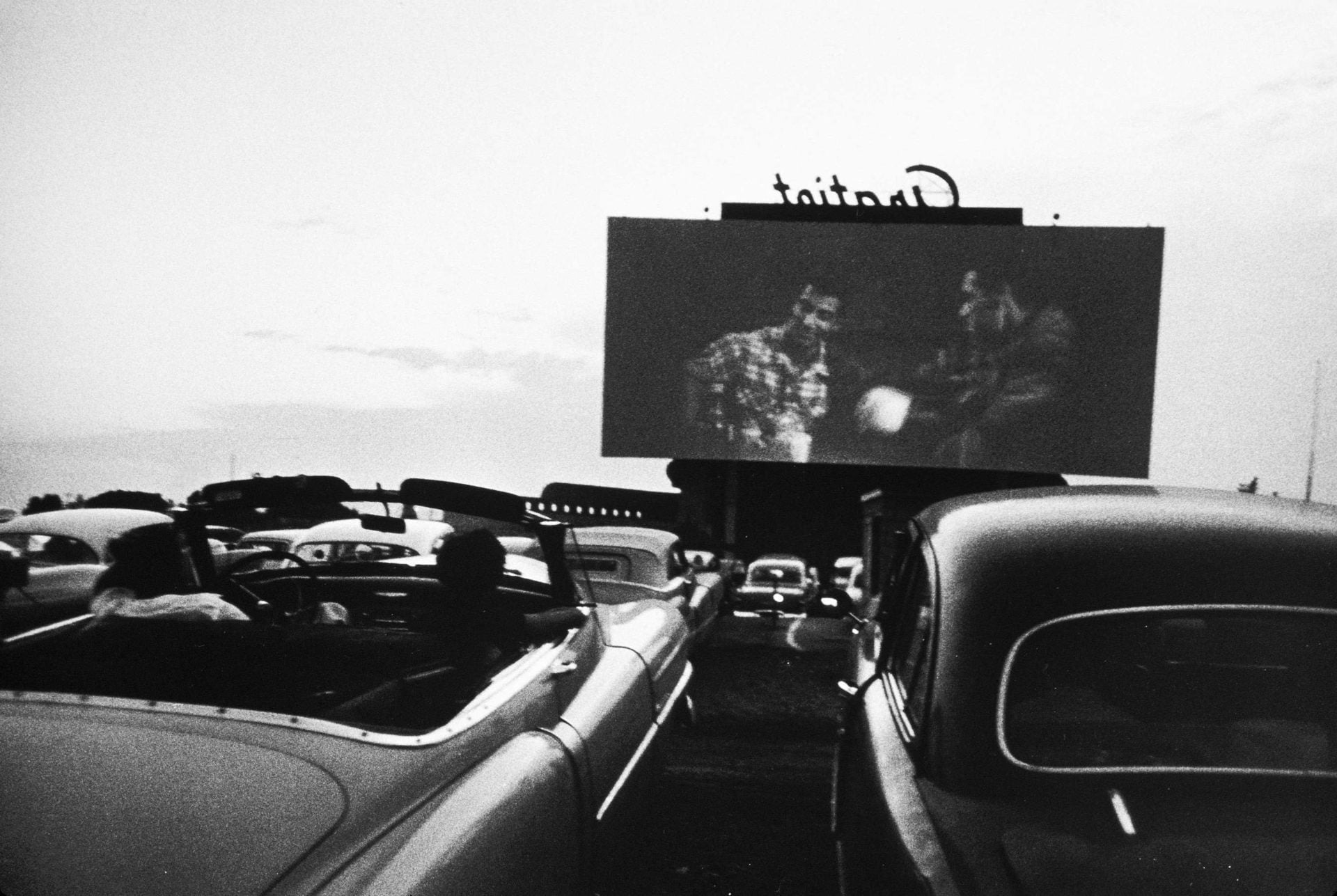 Robert Frank, Drive-in movie, Detroit, 1955 : un écran de cinéma en plein air au-dessus d'un parking de voitures