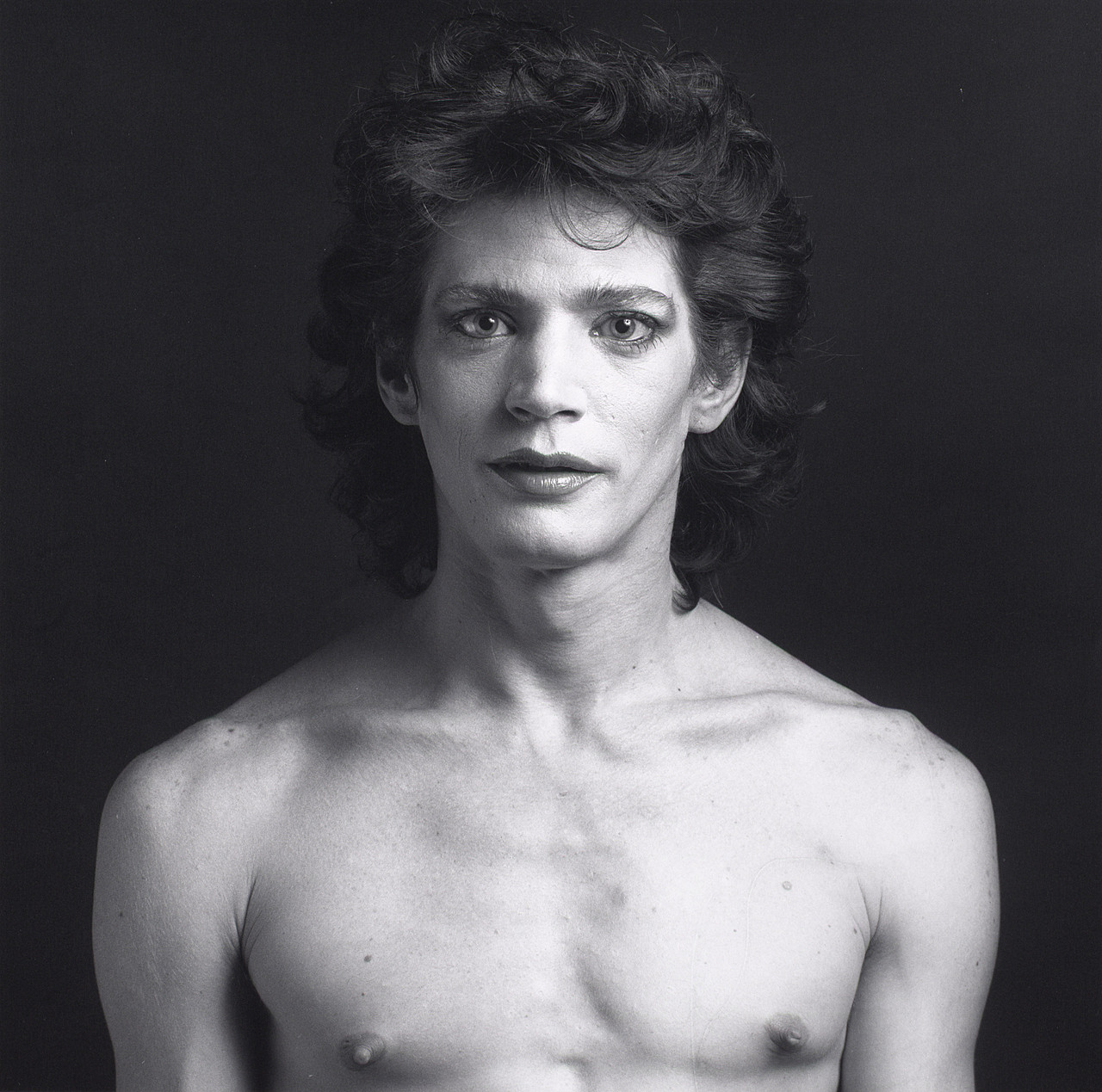 Self Portrait, 1980. Torse nu, cheveux bouclés, le regard qui ne cède pas.
