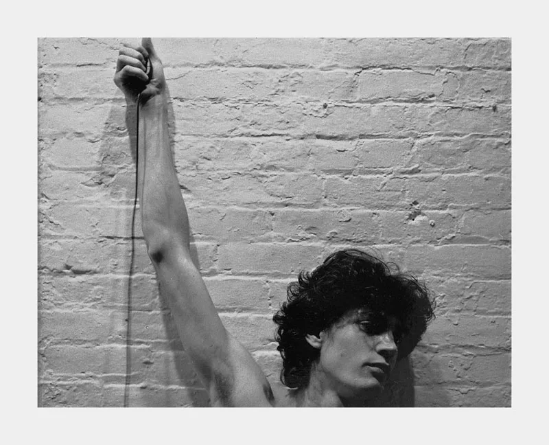Autoportrait au Polaroid, vers 1973. Le bras levé contre un mur de brique : rien d’autre à régler que plus de lumière ou moins.