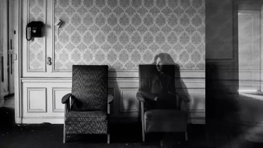 Sophie Calle assise, spectrale, dans un salon de l'hôtel du Palais d'Orsay à l'abandon