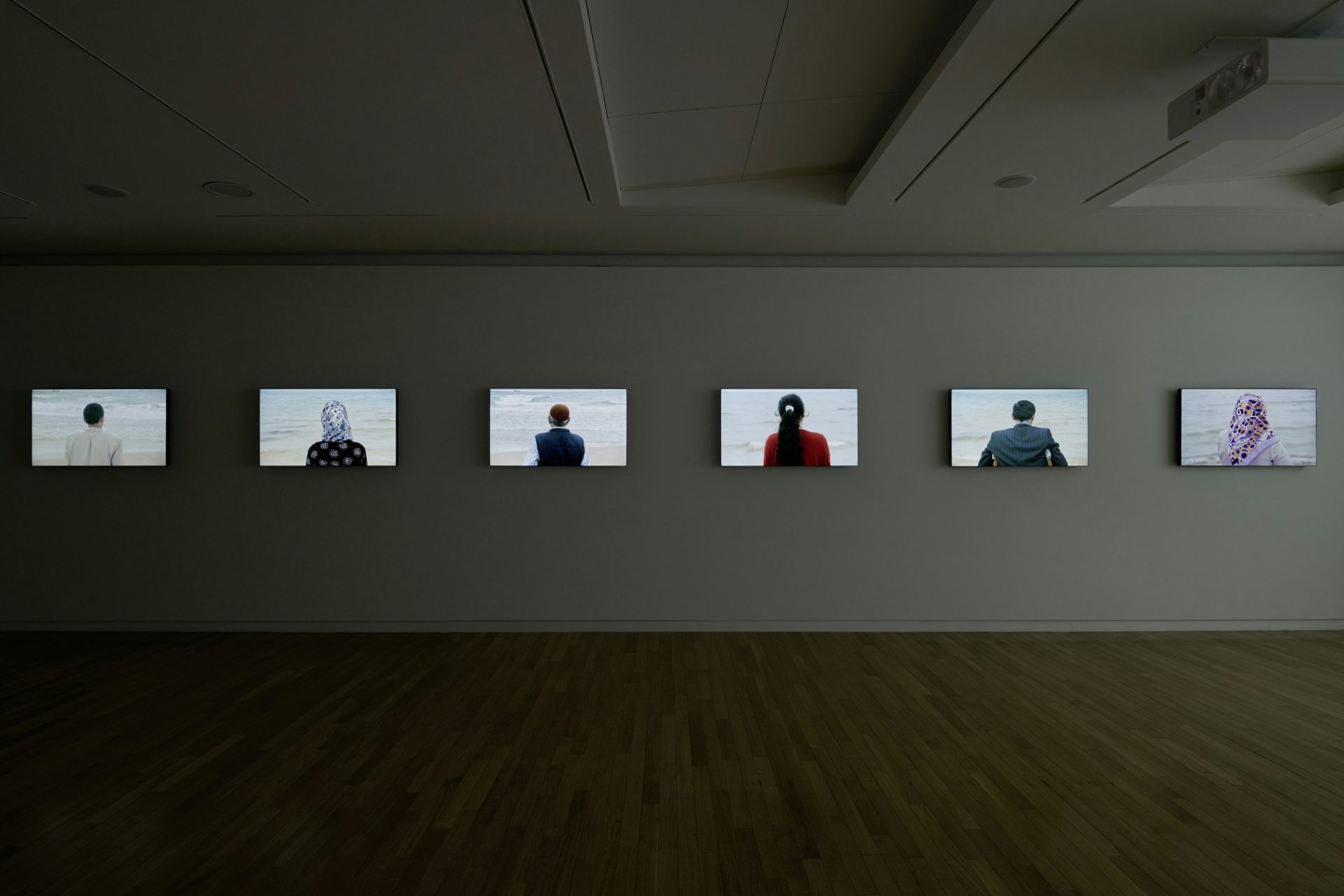 Installation de Voir la mer de Sophie Calle, plusieurs écrans montrant des personnes face à la mer