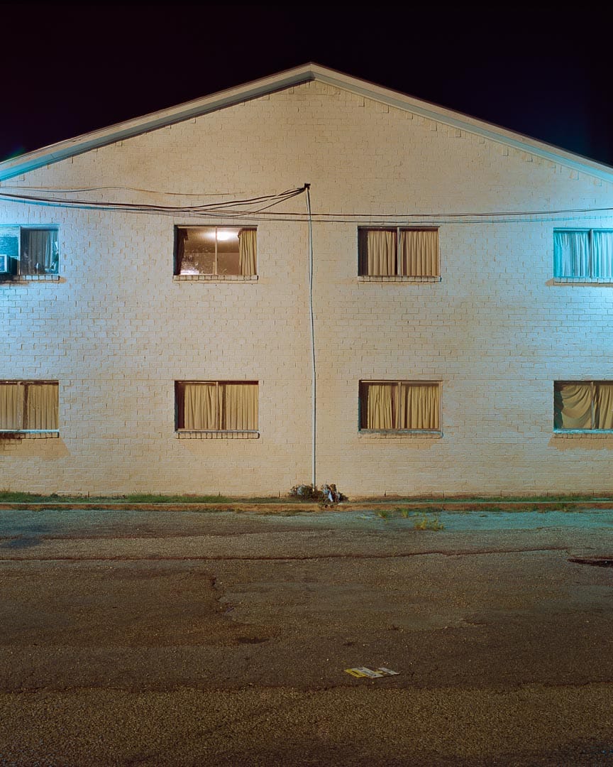 Todd Hido, petit immeuble de nuit, plusieurs fenêtres allumées