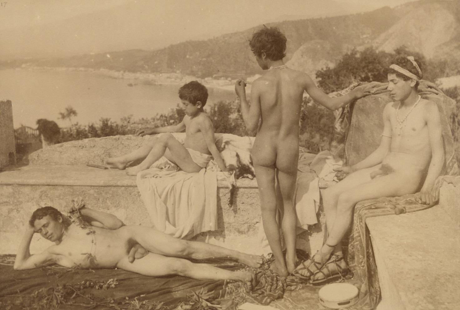 Wilhelm von Gloeden, jeunes gens sur une terrasse de Taormine. Sandales lacées, colliers de perles, tambourin, peaux de bête : les accessoires font tout le travail.